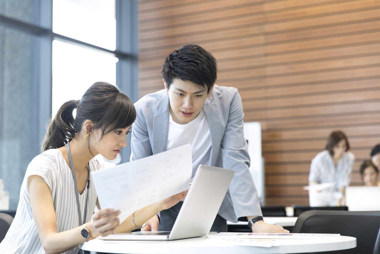 忙しく仕事をする男女